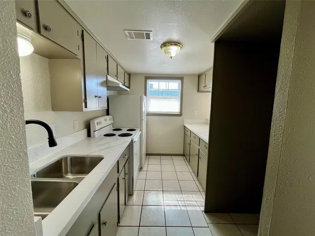 a kitchen with a sink and a stove top oven