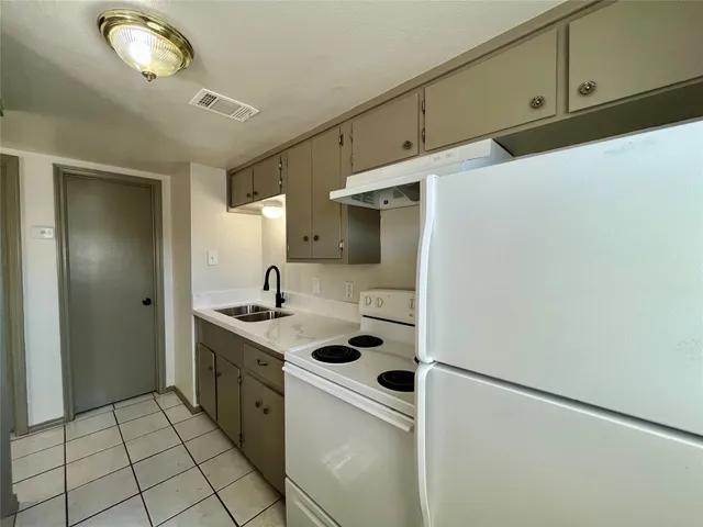 a kitchen with a sink cabinets and appliances