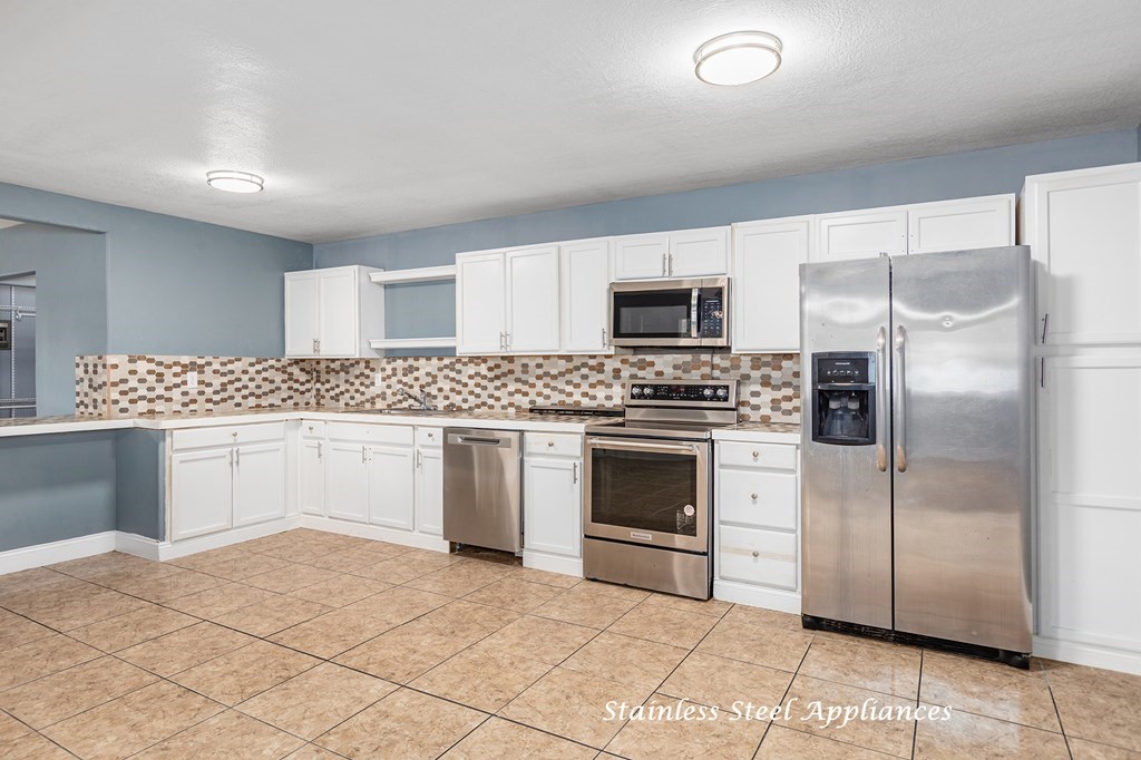 2915 Freeman Street Lufkin, TX 75901 - Photo 12 of 33 a kitchen with granite countertop a refrigerator stove and microwave