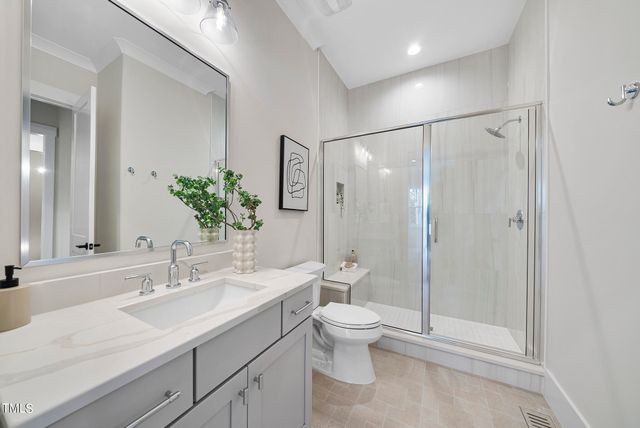 a bathroom with a shower sink vanity mirror and toilet