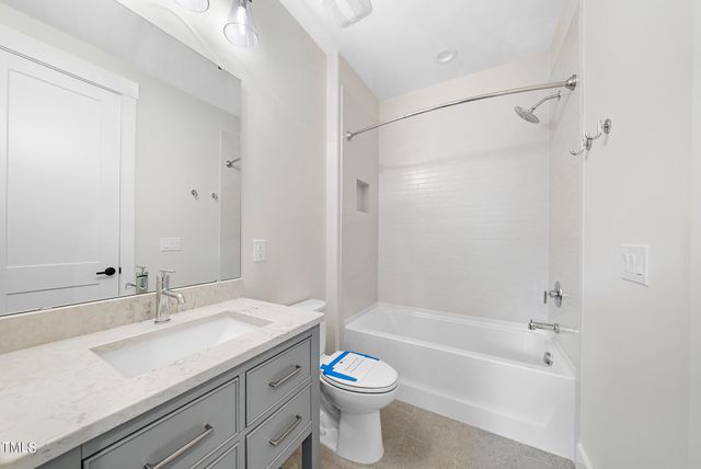 a bathroom with a granite countertop sink a toilet and shower