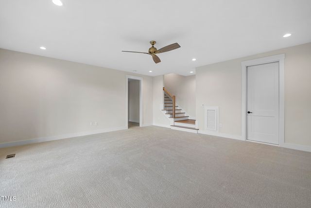 an empty room with a ceiling fan and windows