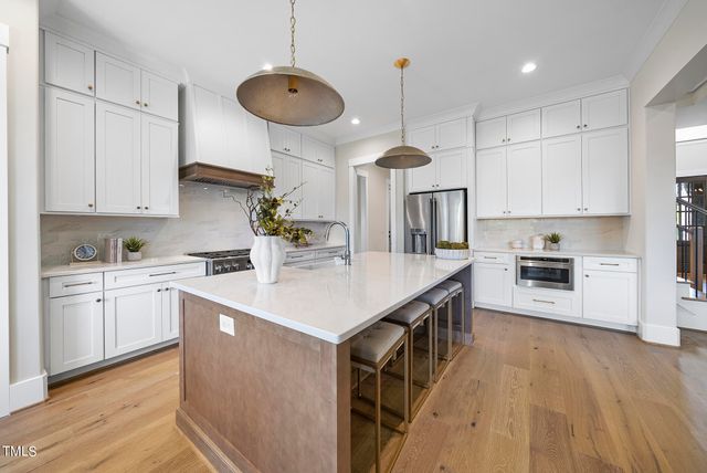 a kitchen with stainless steel appliances granite countertop a sink a stove and a refrigerator