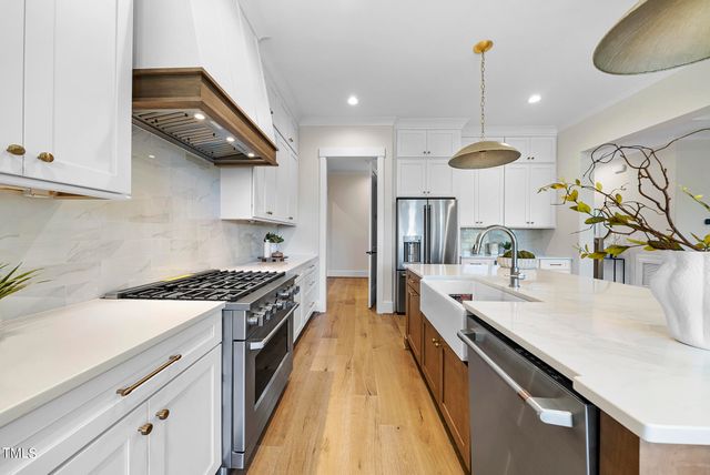a large kitchen with stainless steel appliances granite countertop a lot of counter space and a sink