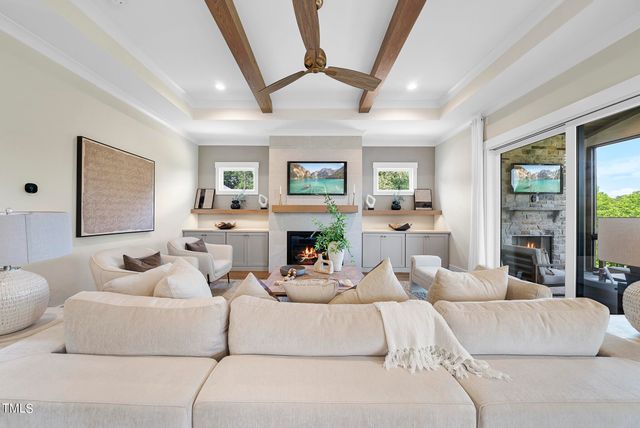 a living room with fireplace furniture and a large window