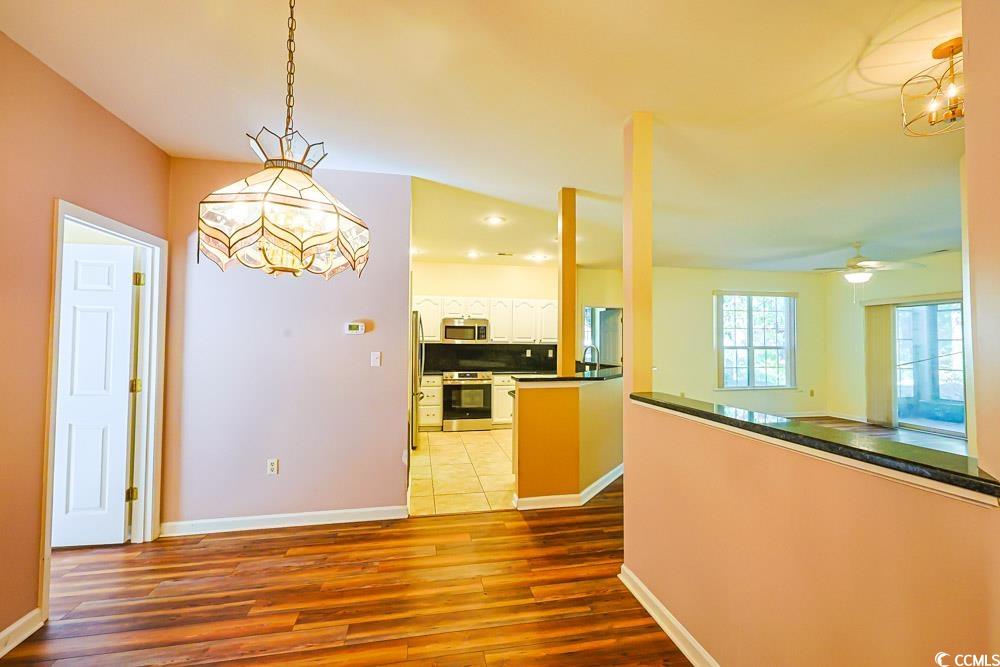 401 Pipers Lane, Unit 401 Myrtle Beach, SC 29575 - Photo 8 of 40 Kitchen featuring pendant lighting, dark wood-style flooring, appliances with stainless steel finishes, ceiling fan, and tasteful backsplash