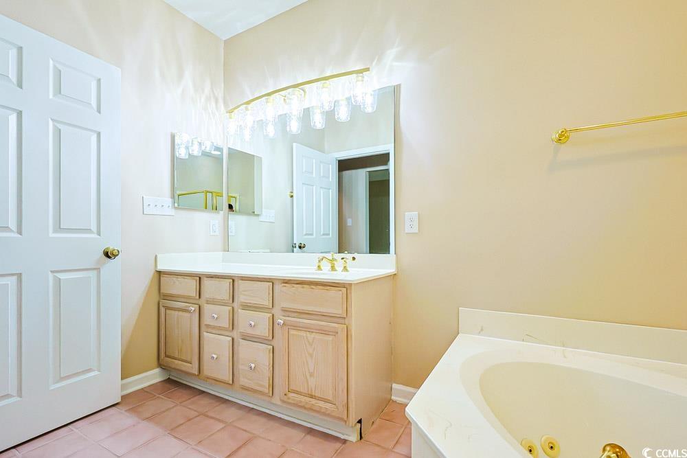401 Pipers Lane, Unit 401 Myrtle Beach, SC 29575 - Photo 11 of 40 Bathroom featuring vanity, light tile patterned floors, and a jetted tub