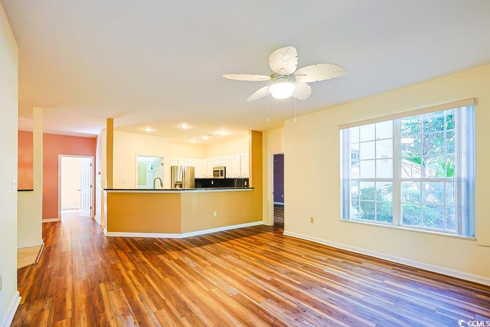 401 Pipers Lane, Unit 401 Myrtle Beach, SC 29575 - Photo 39 of 40 Kitchen with dark wood-style floors, appliances with stainless steel finishes, open floor plan, dark countertops, and a peninsula
