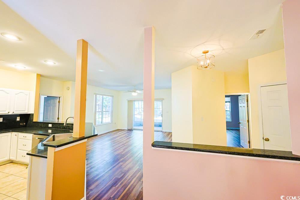 401 Pipers Lane, Unit 401 Myrtle Beach, SC 29575 - Photo 40 of 40 Kitchen with a peninsula, decorative backsplash, ceiling fan, open floor plan, and white cabinets