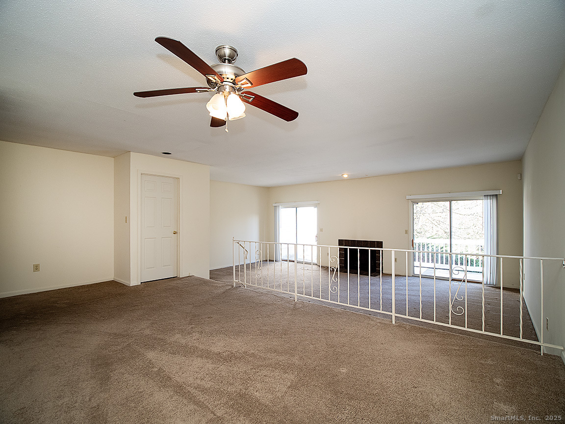 3989 Park Avenue, Unit 3989 Fairfield, CT 06825 - Photo 6 of 37 an empty room with ceiling fan and windows