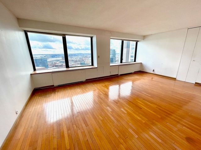 a view of a hallway with wooden floor and closet