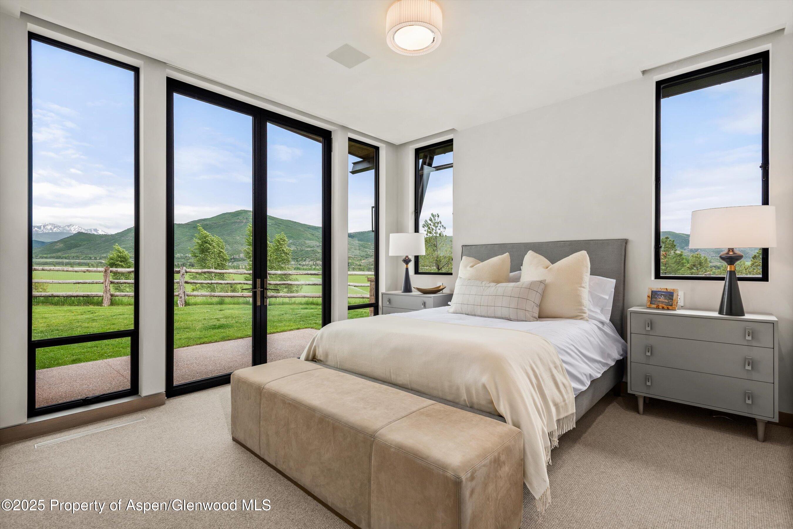 31 Aspen Valley Ranch Road Woody Creek, CO 81656 - Photo 25 of 52 a bedroom with a bed and a large window