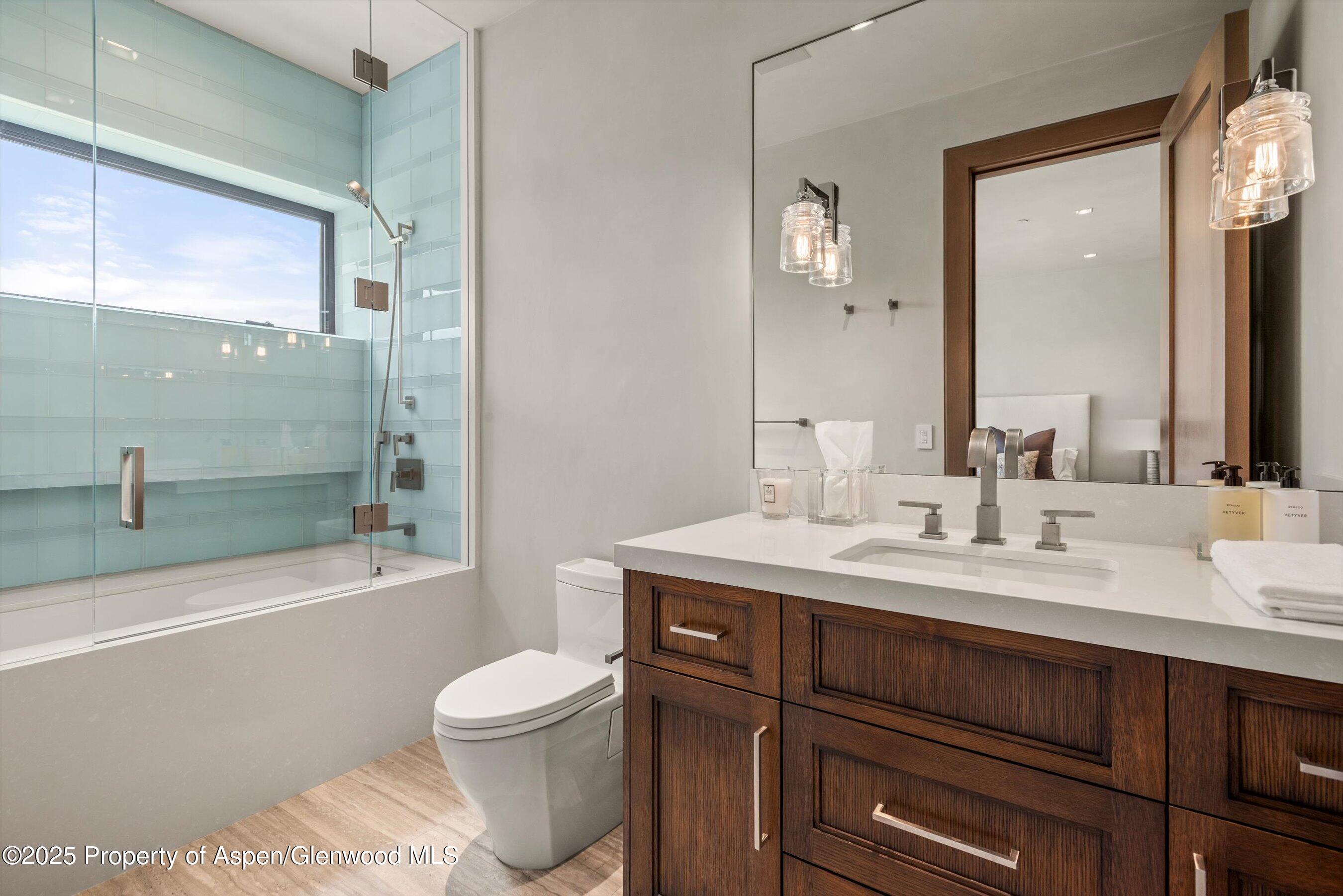 31 Aspen Valley Ranch Road Woody Creek, CO 81656 - Photo 30 of 52 a bathroom with a granite countertop sink toilet a large mirror a bathtub and shower