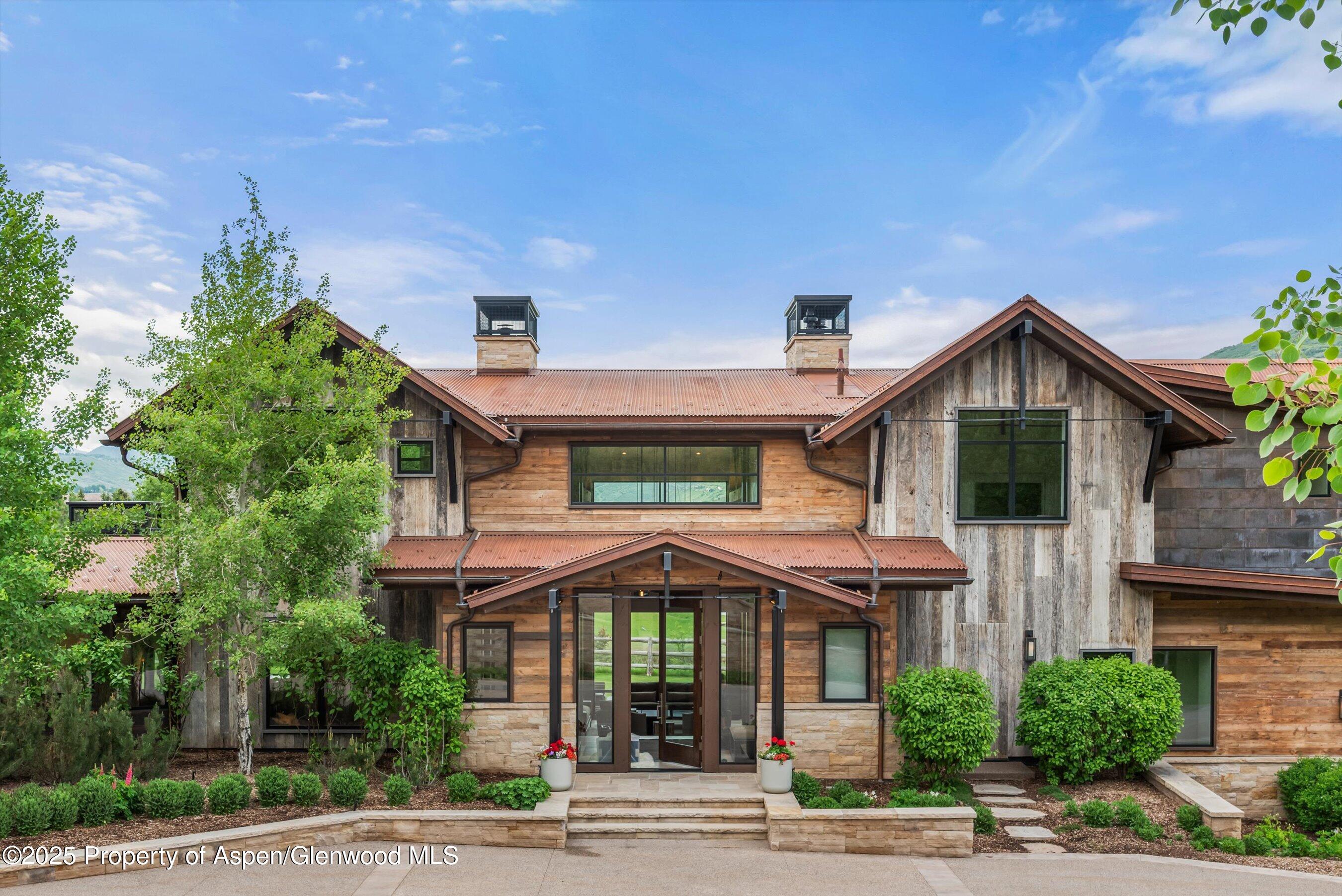 31 Aspen Valley Ranch Road Woody Creek, CO 81656 - Photo 3 of 52 a front view of a house with a yard and potted plants