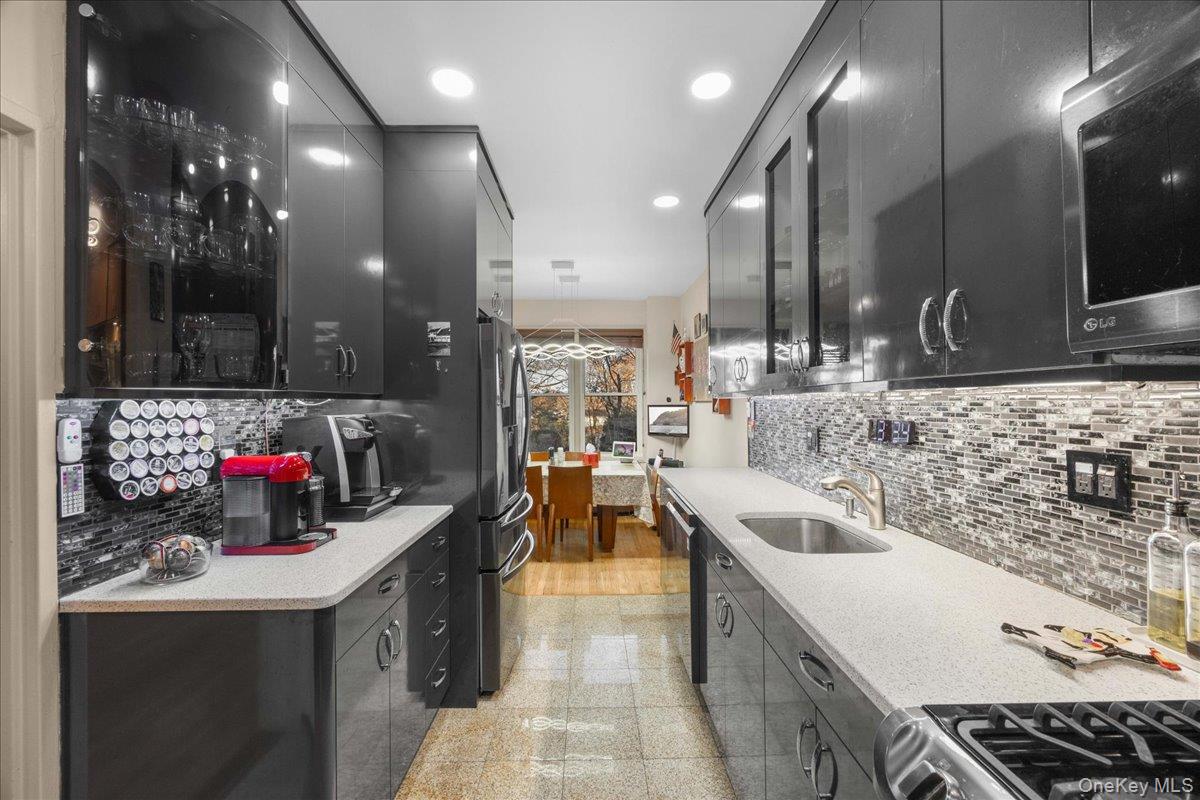 1015 Old Boston Post Road, Unit 2C Mamaroneck, NY 10543 - Photo 11 of 26 Kitchen with dark cabinets, stainless steel appliances, granite tiled floors, glass insert cabinets, and recessed lighting
