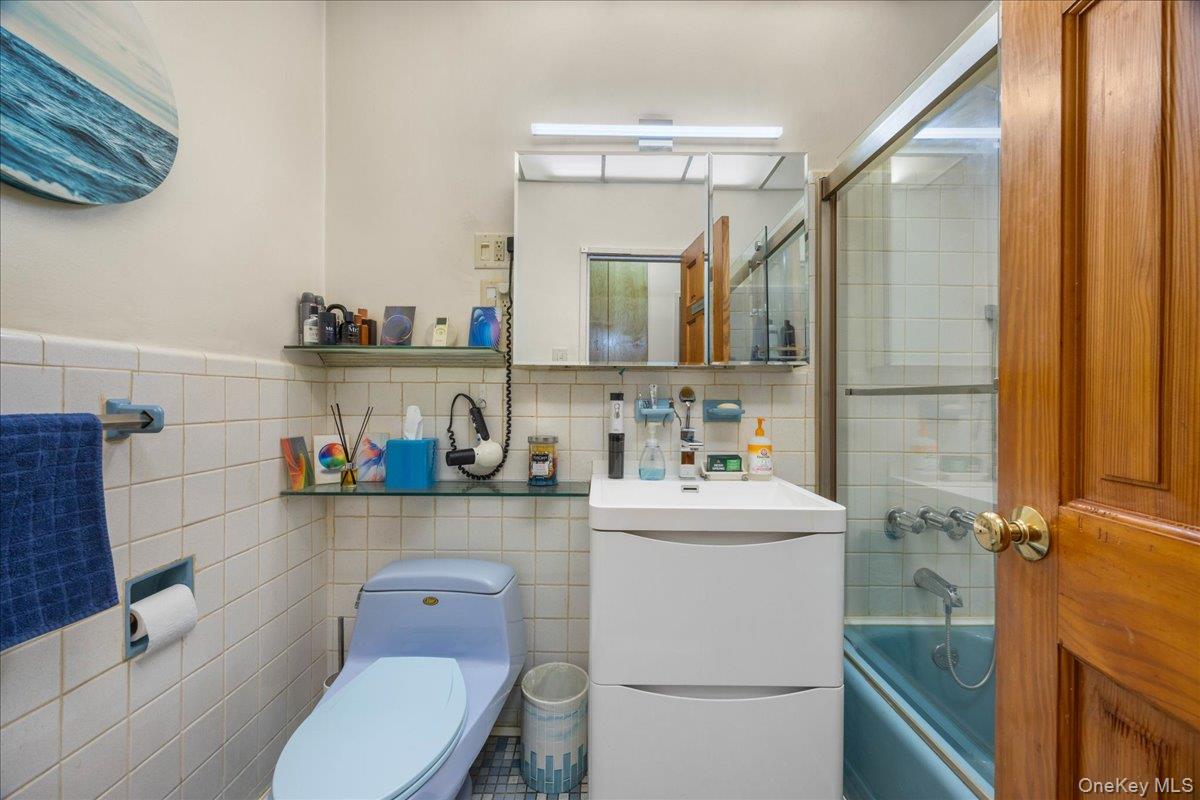1015 Old Boston Post Road, Unit 2C Mamaroneck, NY 10543 - Photo 12 of 26 Bathroom featuring vanity, enclosed tub / shower combo, and tile walls