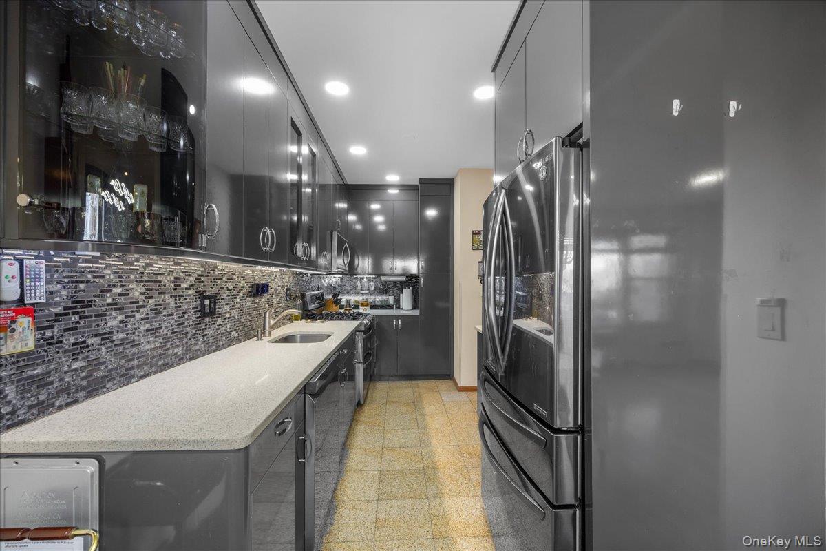 1015 Old Boston Post Road, Unit 2C Mamaroneck, NY 10543 - Photo 9 of 26 Kitchen with tasteful backsplash, stainless steel appliances, modern cabinets, light stone countertops, and recessed lighting