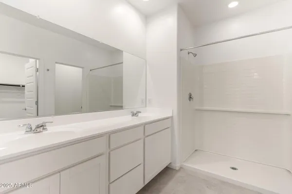 a bathroom with a double vanity sink mirror and shower