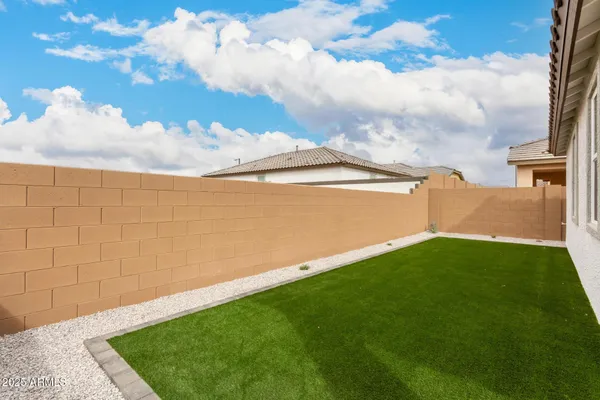a view of yard with swimming pool and brick wall