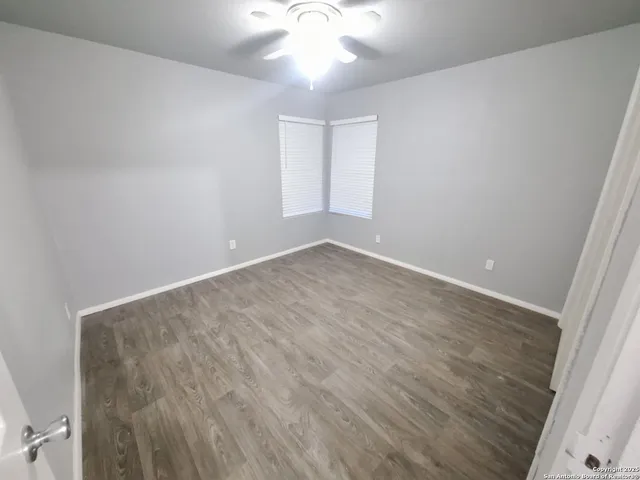 wooden floor in an empty room with a window