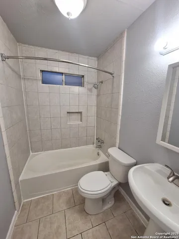 a bathroom with a toilet a sink and bathtub