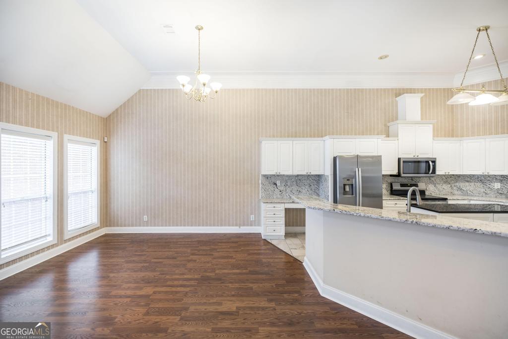 209 Trellis Walk Centerville, GA 31028 - Photo 16 of 38 a kitchen with stainless steel appliances granite countertop a sink a stove and a wooden floors