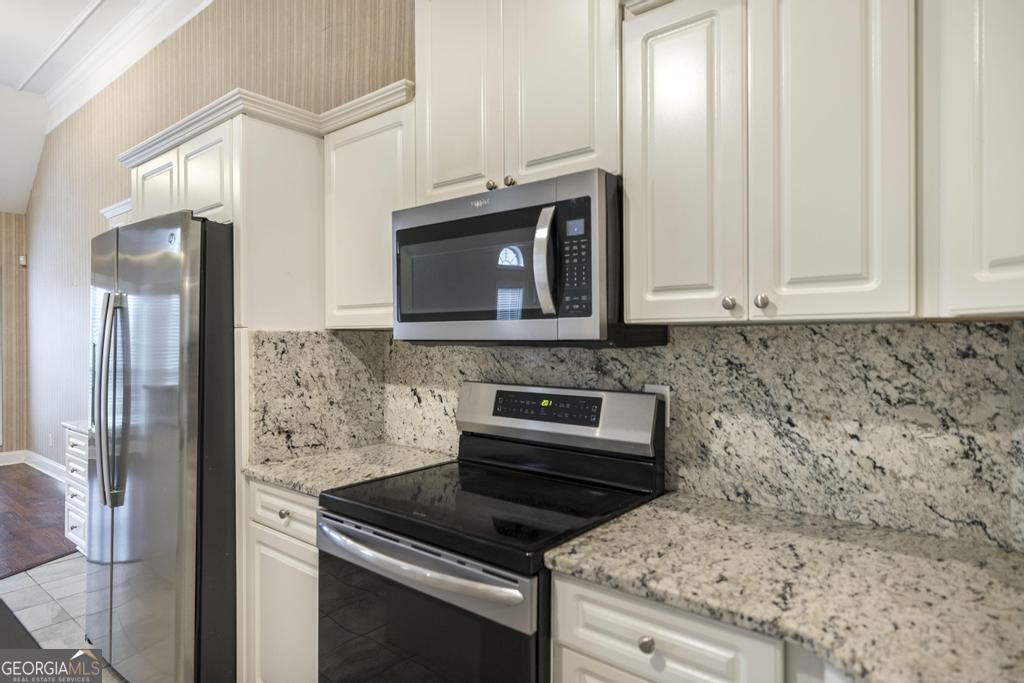 209 Trellis Walk Centerville, GA 31028 - Photo 21 of 38 a kitchen with granite countertop cabinets stainless steel appliances and a counter space