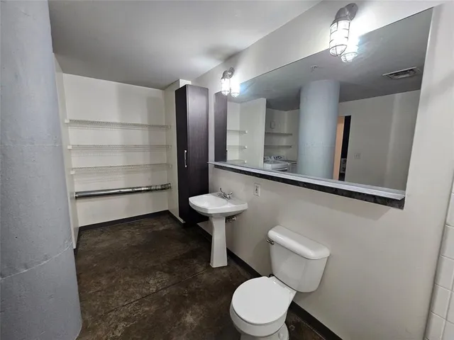 a bathroom with a toilet a sink and mirror