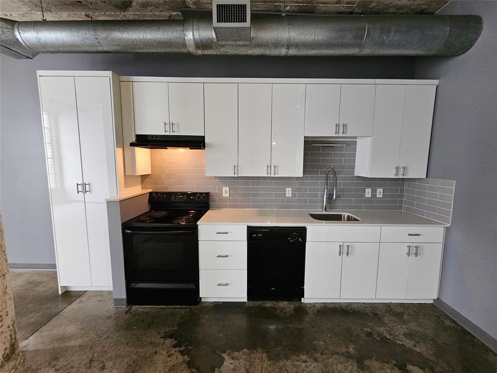 1122 Jackson Street, Unit 919 Dallas, TX 75202 - Photo 4 of 21 a kitchen with granite countertop a refrigerator sink and cabinets