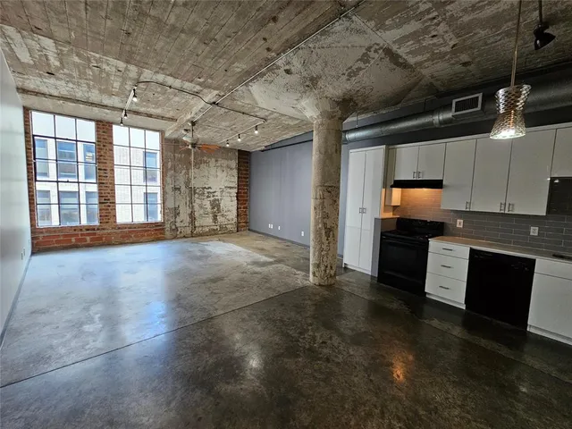 a view of an empty room with kitchen