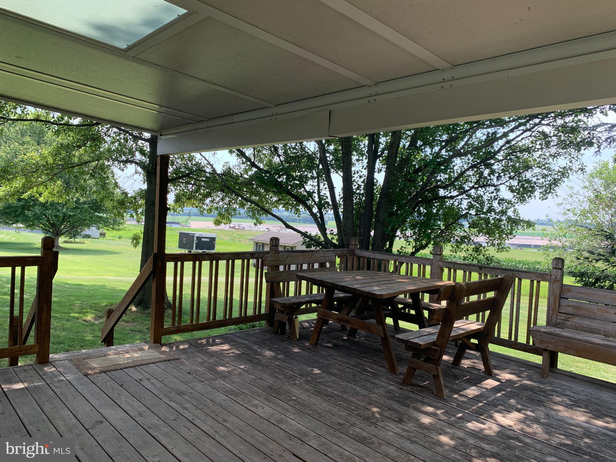 549 Hi View Drive Lititz, PA 17543 - Photo 34 of 42 a view of a patio with table and chairs under an umbrella with wooden floor and fence
