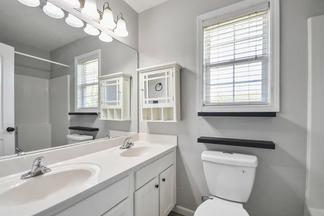 a bathroom with a toilet a sink and a large mirror
