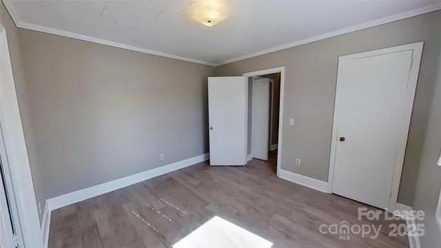 an empty room with wooden floor and closet