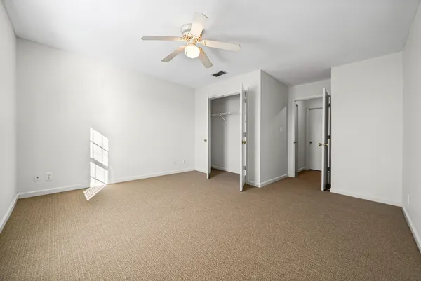 a view of an empty room with a ceiling fan