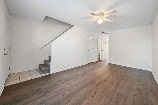 an empty room with wooden floor and ceiling fan