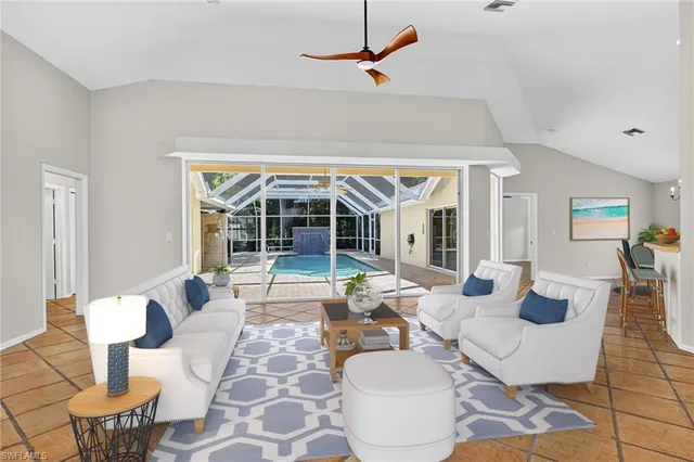 a living room with patio furniture and a large window