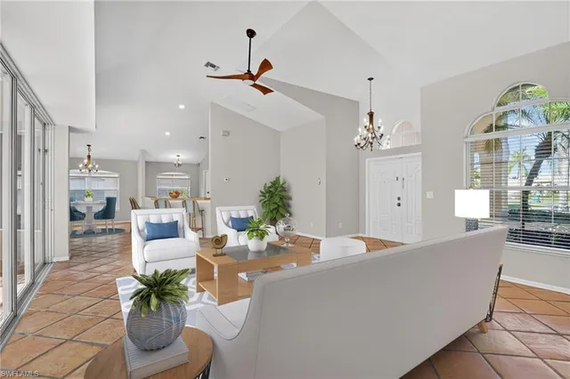 a dining room with furniture a chandelier and wooden floor
