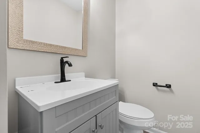 a bathroom with a sink a toilet and mirror