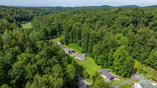an aerial view of a house with a lush green forest