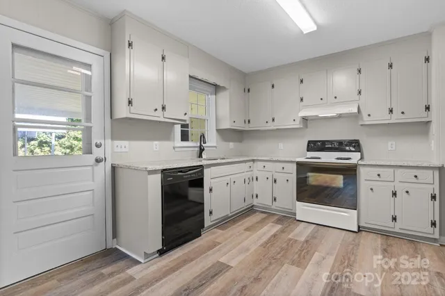 a kitchen with granite countertop white cabinets and white appliances