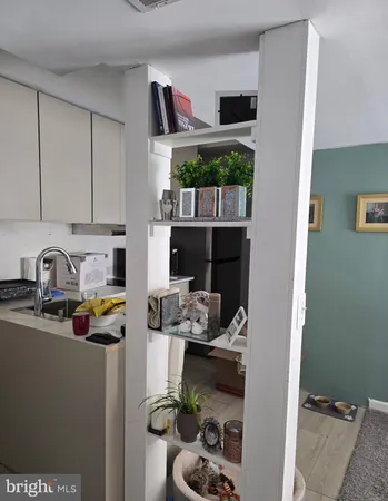 a kitchen with stainless steel appliances a sink a stove a refrigerator and cabinets