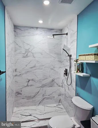 a bathroom with a toilet and a shower