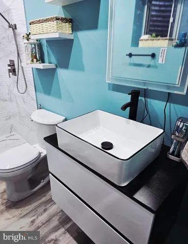 a white toilet sitting next to a bathroom sink and a mirror