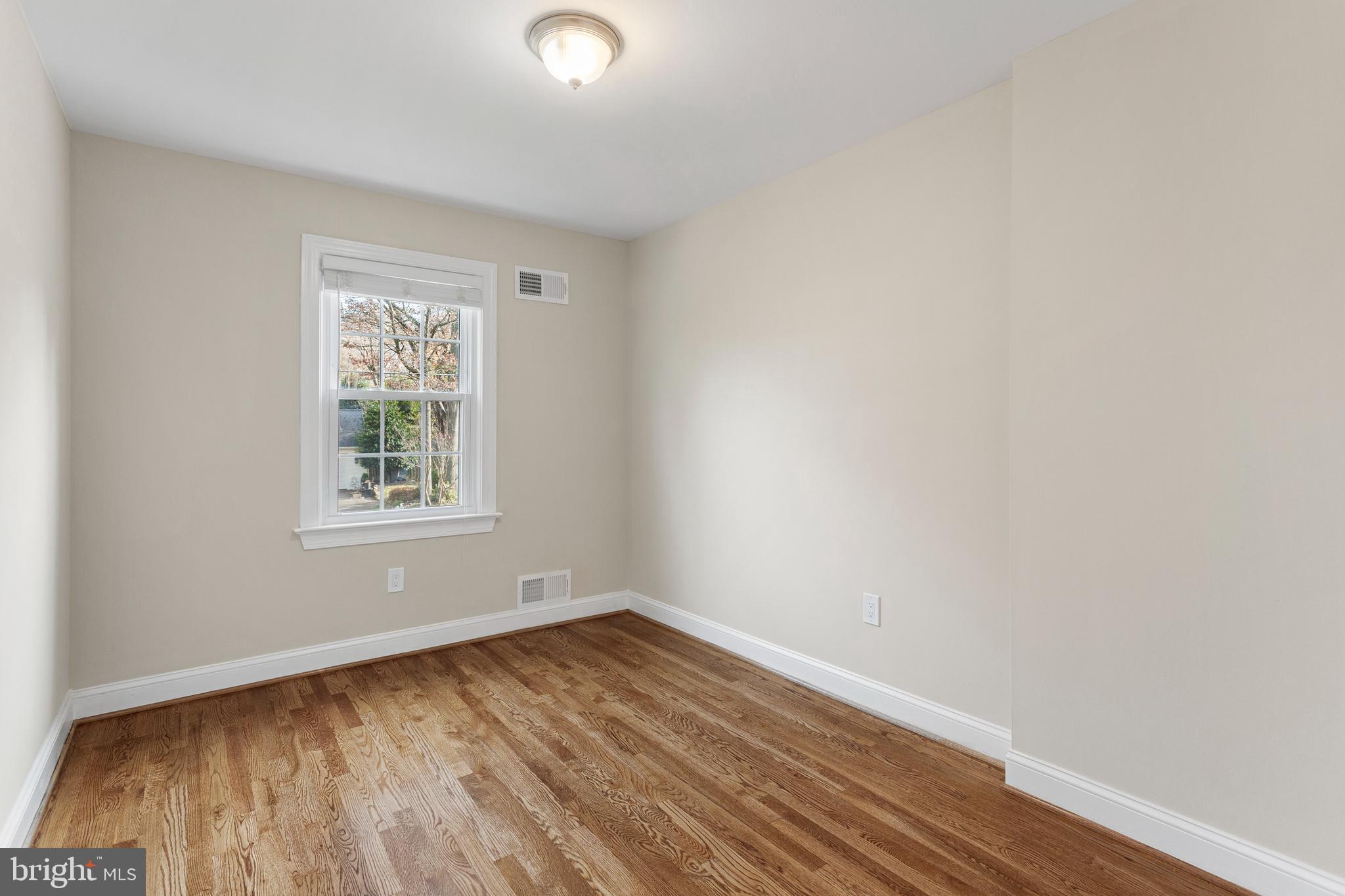 8403 Harker Drive Potomac, MD 20854 - Photo 18 of 33 an empty room with wooden floor and windows