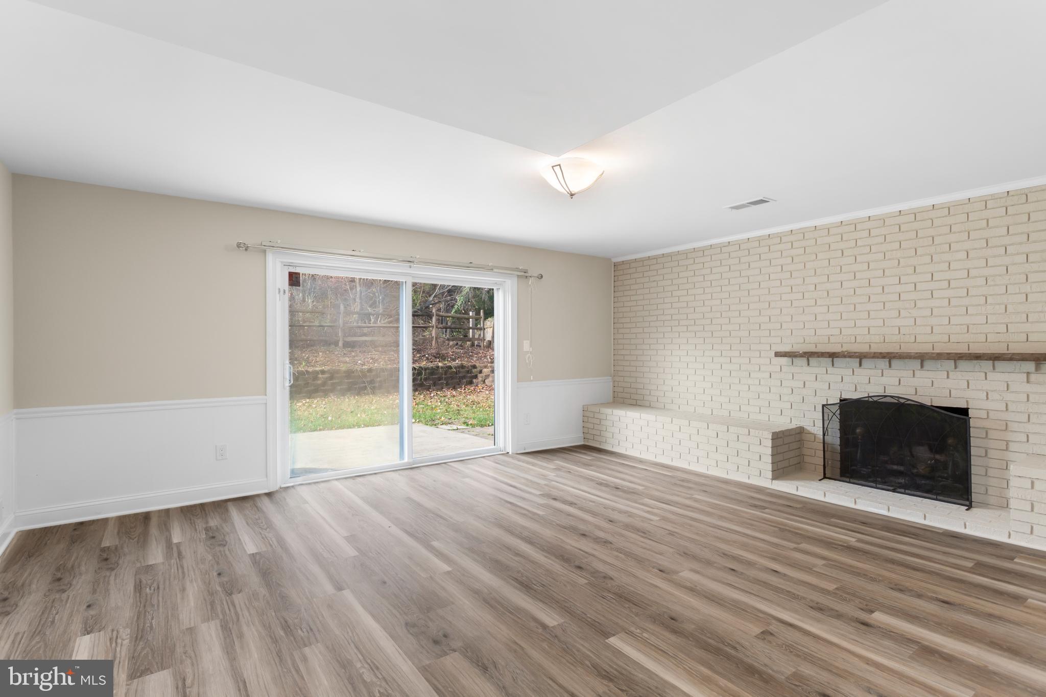 8403 Harker Drive Potomac, MD 20854 - Photo 24 of 33 a view of empty room with wooden floor and fireplace