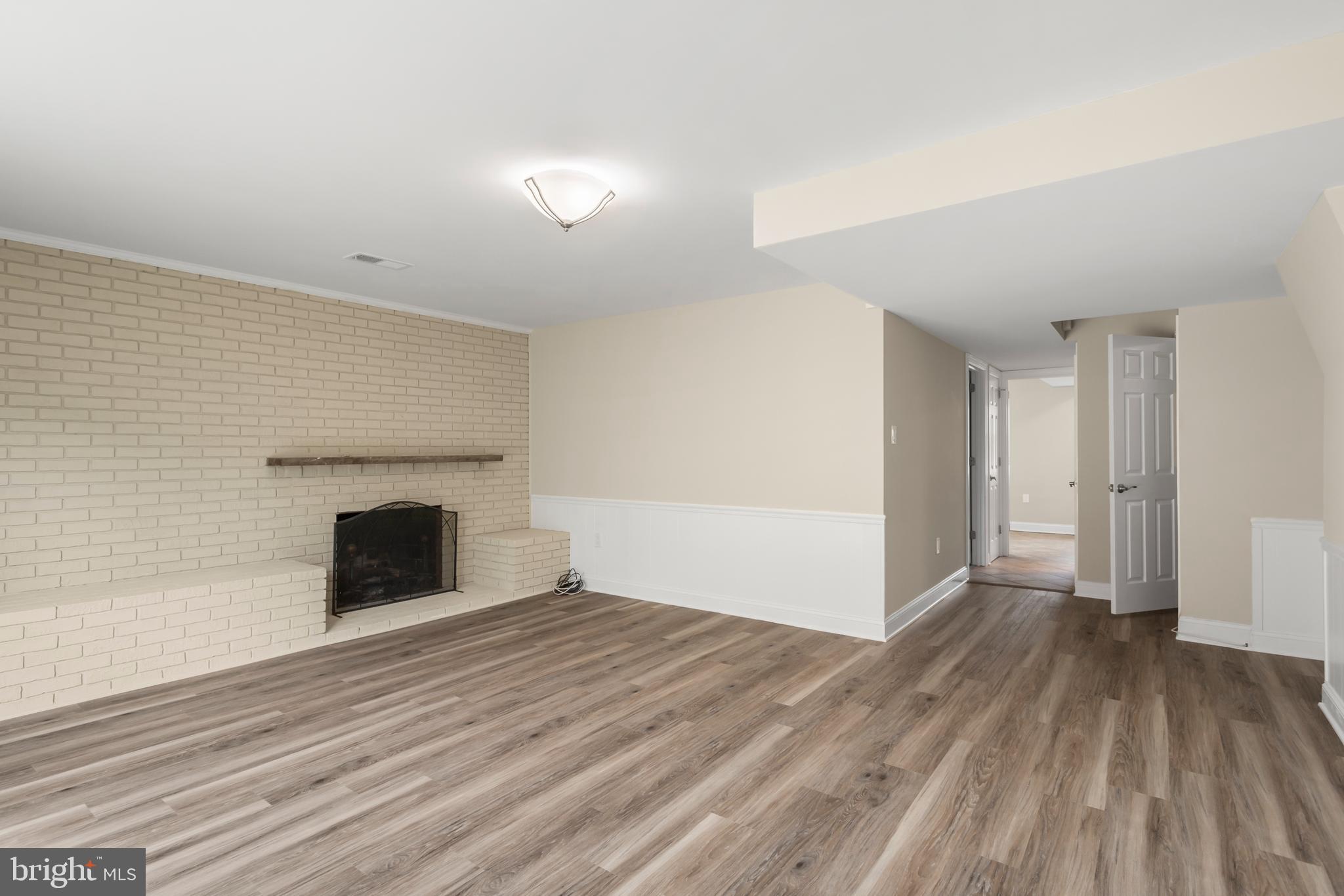 8403 Harker Drive Potomac, MD 20854 - Photo 25 of 33 a view of empty room with wooden floor and fireplace