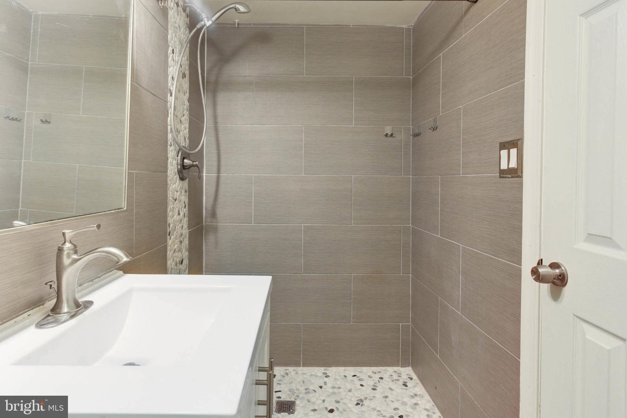 8403 Harker Drive Potomac, MD 20854 - Photo 31 of 33 a bathroom with a sink a shower and a mirror