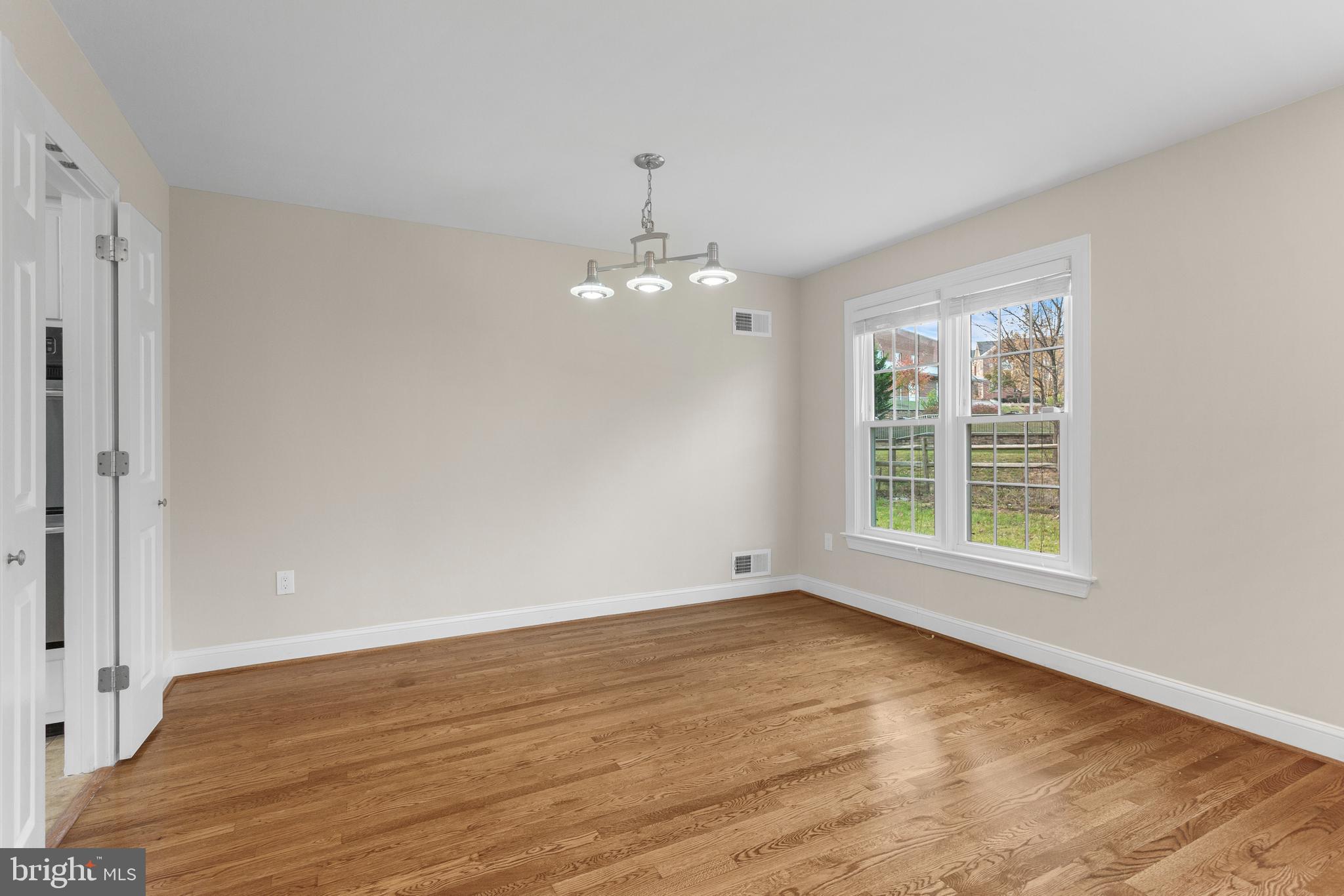 8403 Harker Drive Potomac, MD 20854 - Photo 5 of 33 a view of an empty room with wooden floor and a window