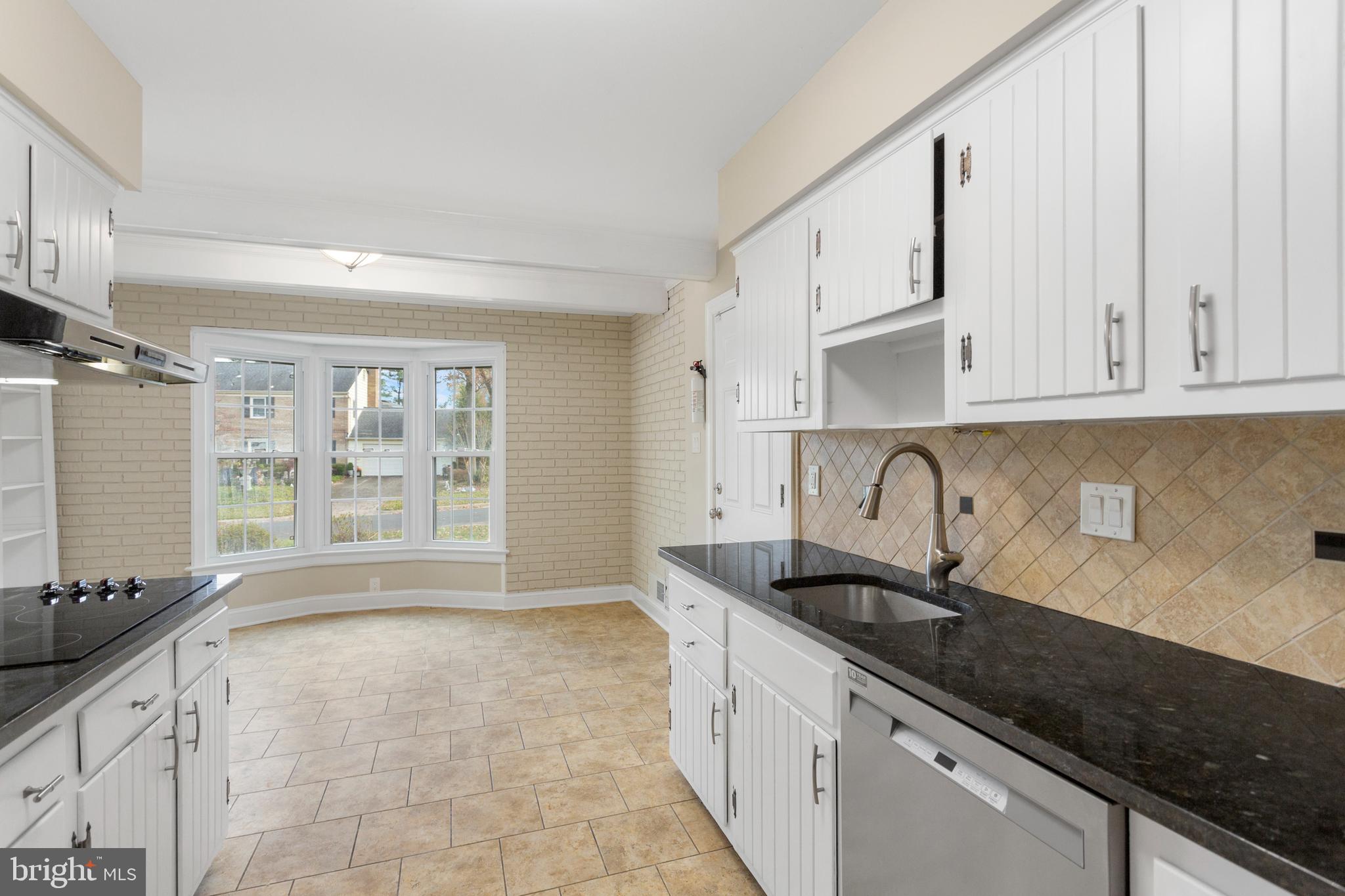 8403 Harker Drive Potomac, MD 20854 - Photo 7 of 33 a kitchen with granite countertop a sink a stove and cabinets