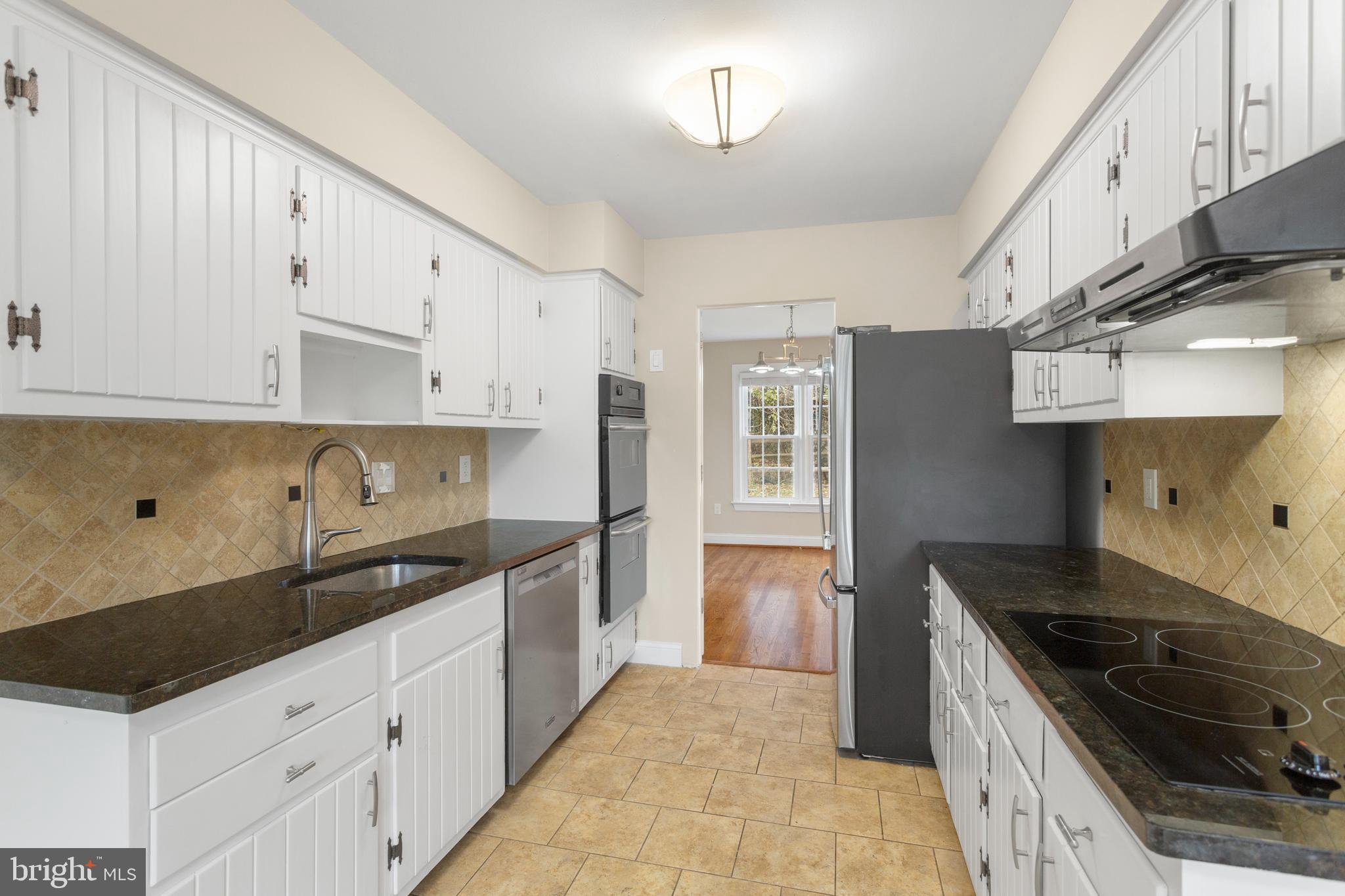 8403 Harker Drive Potomac, MD 20854 - Photo 9 of 33 a kitchen with granite countertop a sink stove and refrigerator